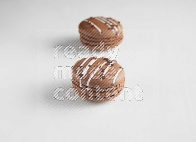 45º Shot of two Brown white Chocolate Caramel macarons on white background