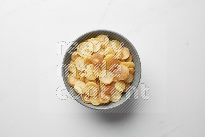 Top-view shot of plain cereal pancakes in a round bowl on white background