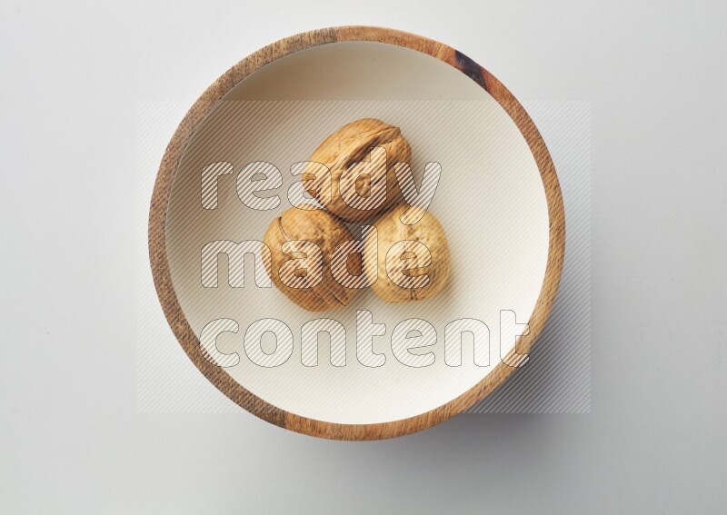 Top-view shot of walnut in a container on white background