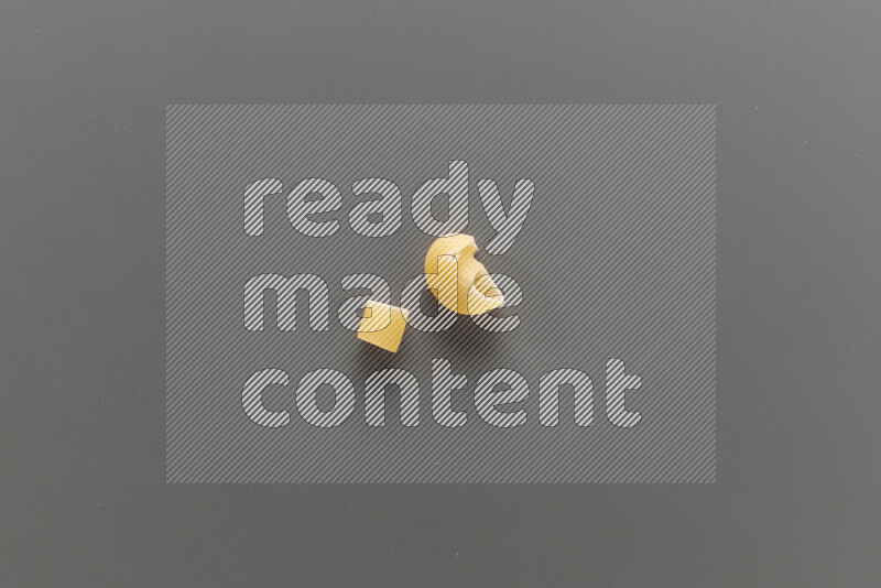 Big rings pasta with other types of pasta on grey background