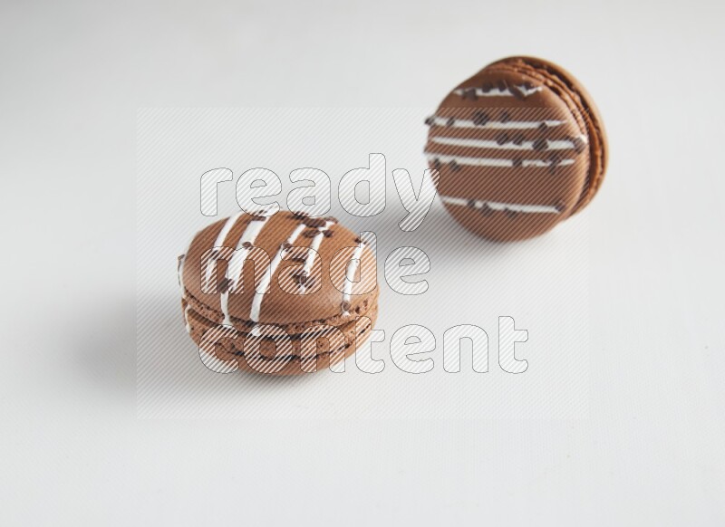 45º Shot of two Brown white Chocolate Caramel macarons on white background