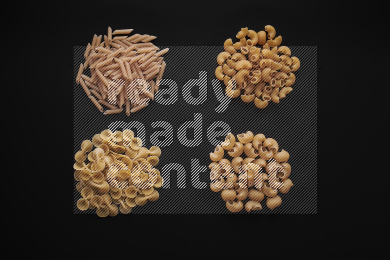 Different pasta types in bunches on black background