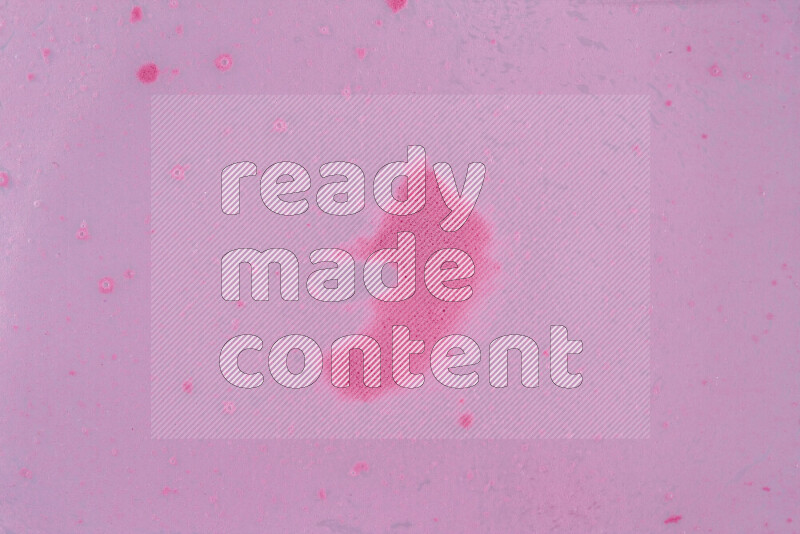 The image captures a dramatic splatter of pink paint over a white backdrop