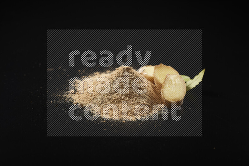 A bunch of ground ginger powder on black background