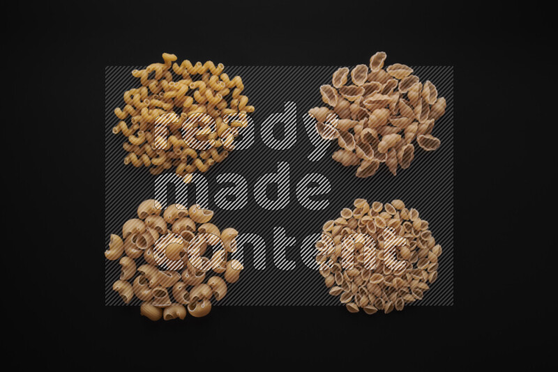 Different pasta types in bunches on black background