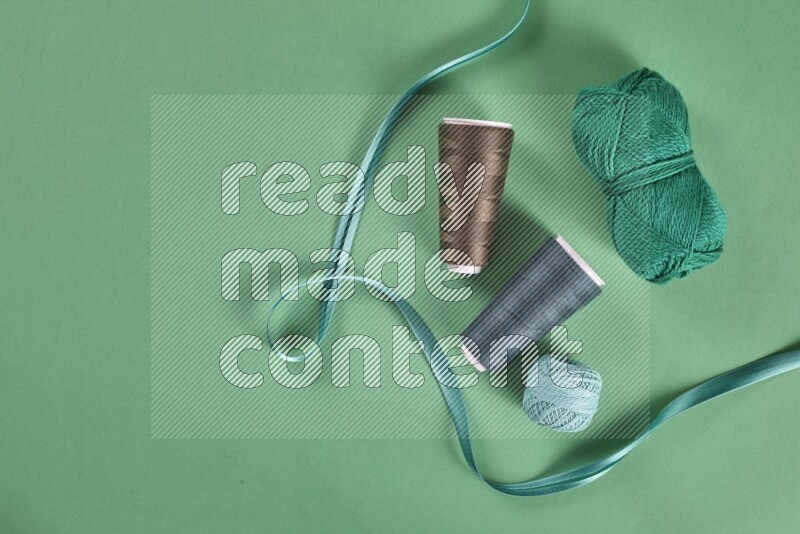 A green collection of sewing and tailoring tools arranged on a green background