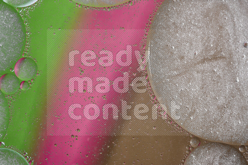 Close-ups of abstract oil bubbles on water surface in shades of brown, green and pink