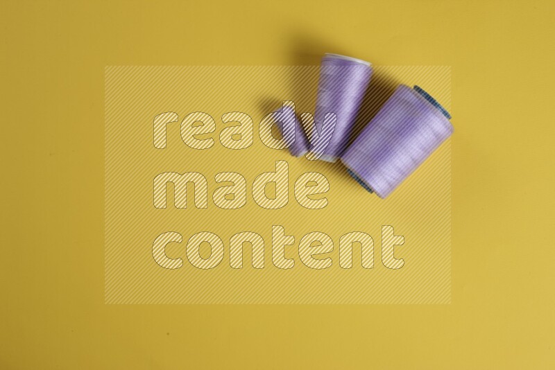 مجموعة من أدوات الخياطة والتفصيل إرجوانية اللون على خلفية صفراء