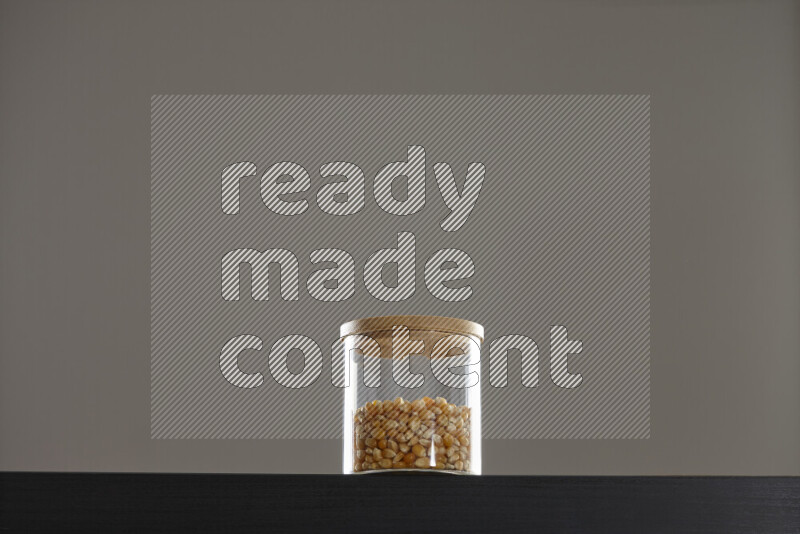 Pop corn in a glass jar on black background