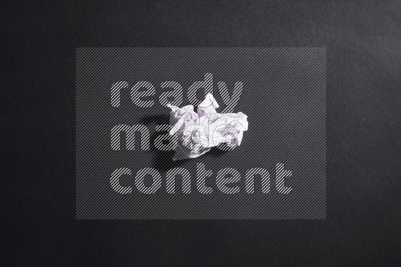 Crumpled notebook sheet on black background