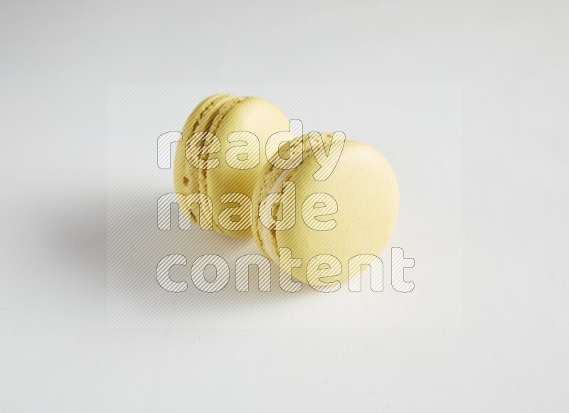 45º Shot of two Yellow Lime macarons on white background