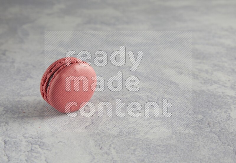 45º Shot of Pink Raspberry macaron on white  marble background