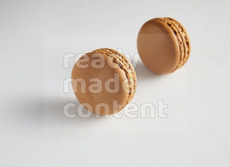45º Shot of two Brown Maple Taffy macarons on white background
