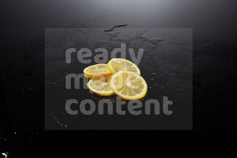 Lemon slices with water drops, and droplets on black background