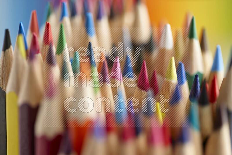 The image captures a close-up of sharpened colored pencils on multicolored background