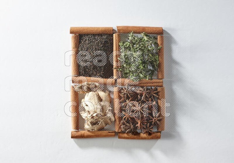 4 squares of cinnamon sticks full of tea, mint, star anise and ginger on white flooring