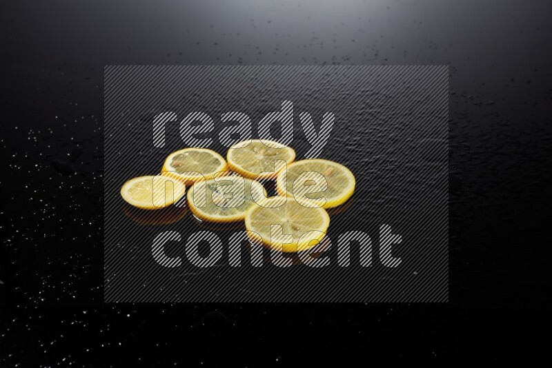 Lemon slices with water drops, and droplets on black background
