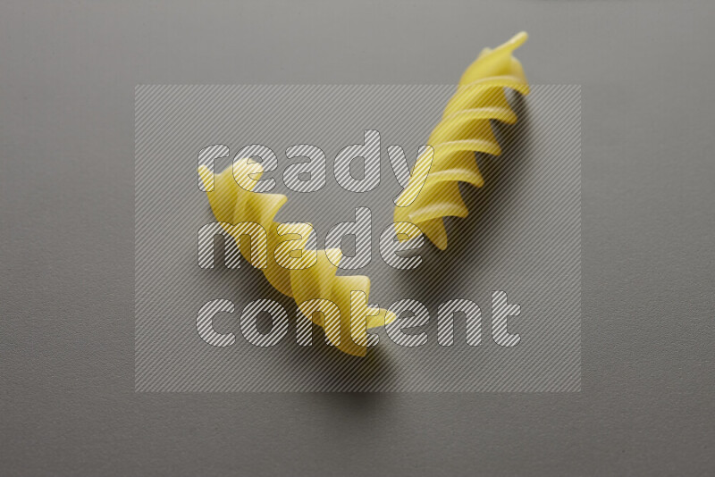 Fusilli pasta on grey background