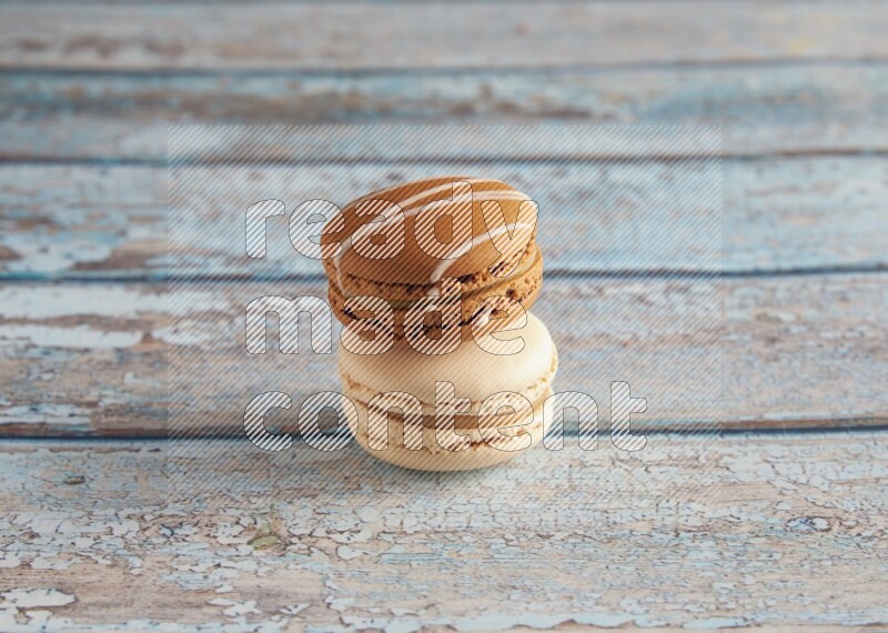 45º Shot of of two assorted Brown Irish Cream, and White Caramel fleur de sel macarons on light blue background