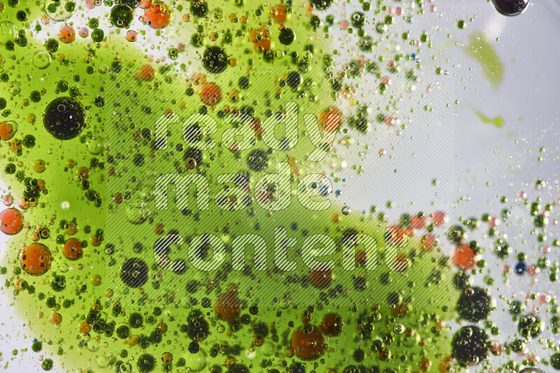 Close-ups of abstract green and red watercolor drops on oil Surface on white background