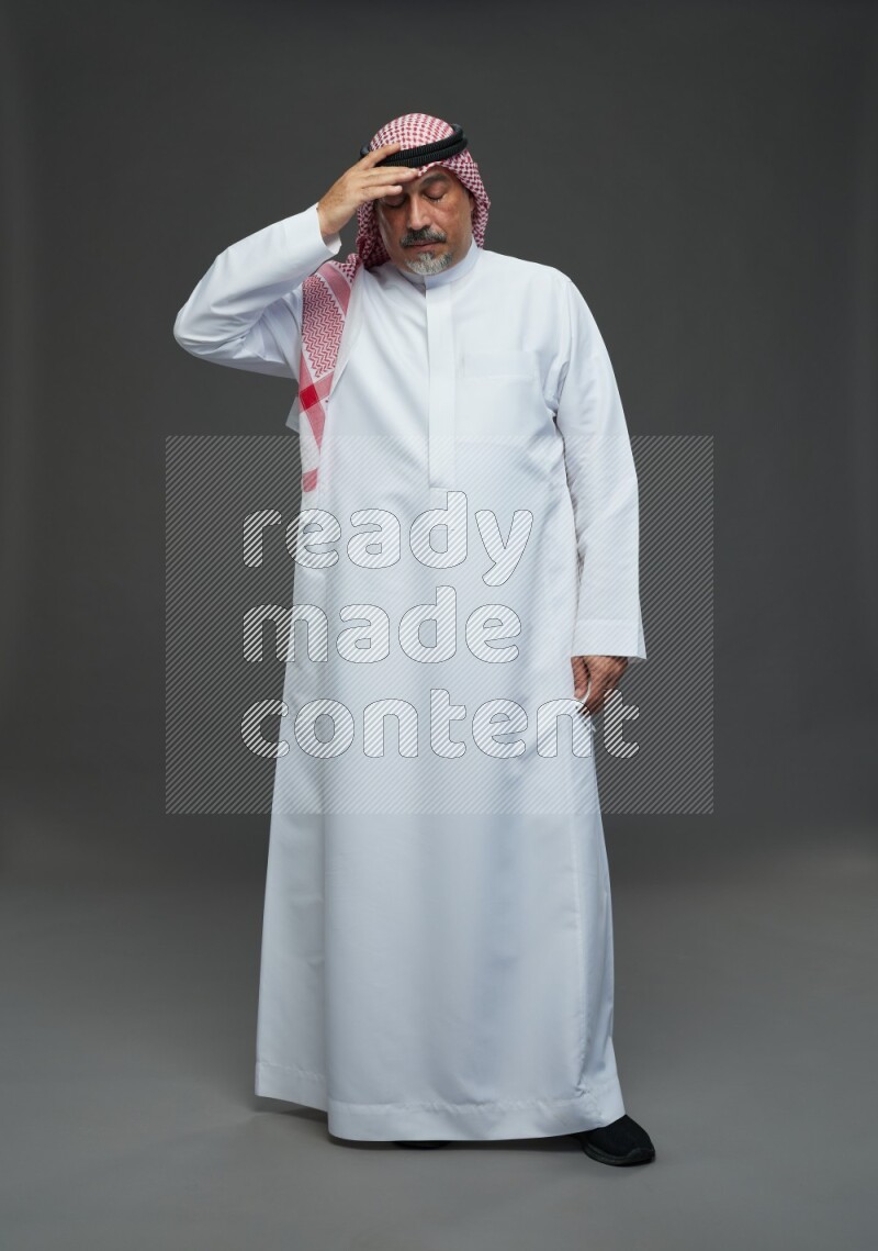 Saudi man with shomag Standing feeling sick on gray background