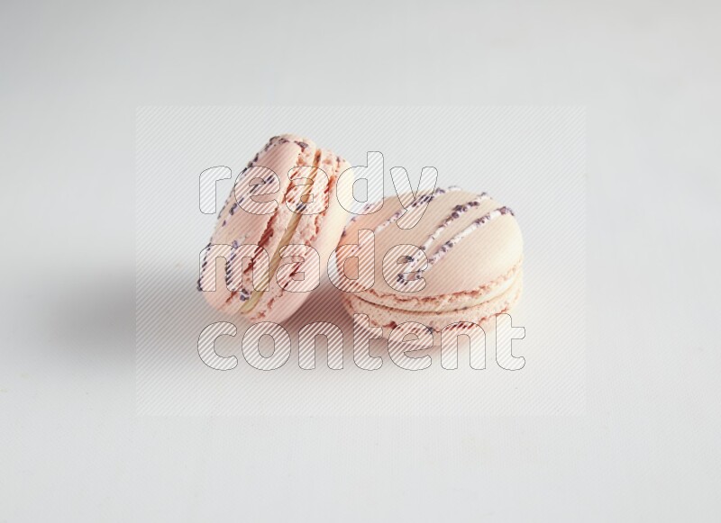 45º Shot of two pink orange blossom macarons on white background