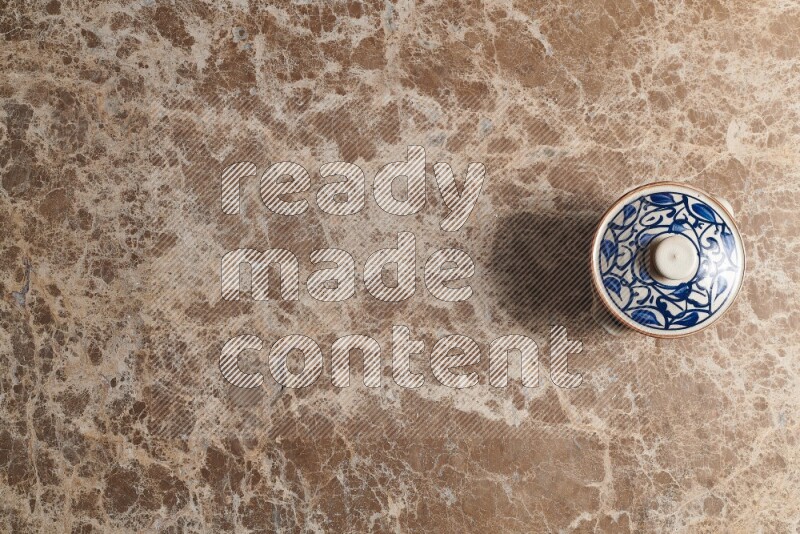 A multicolored pottery pot on beige marble background