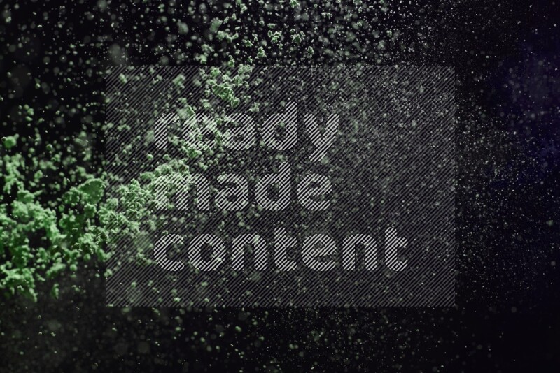 Green powder explosion on black background