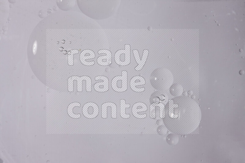 قطرات من الزيت على سطح الماء على خلفية بيضاء