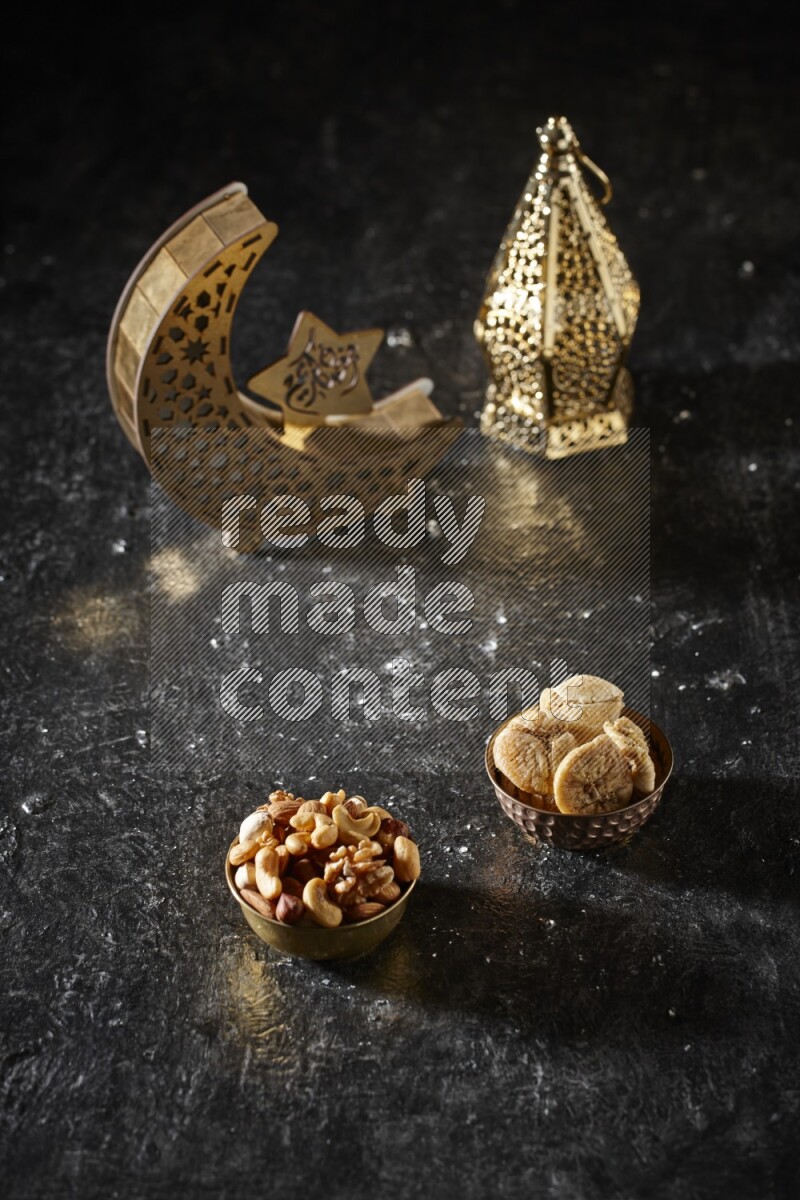 مكسرات في وعاء معدني مع التين المجفف بجانب فوانيس ذهبية علي خلفية سوداء