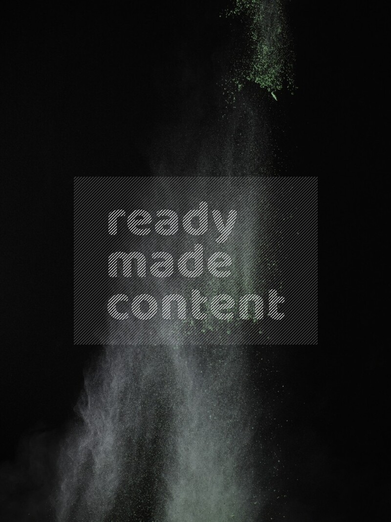 A side view of green powder explosion on black background