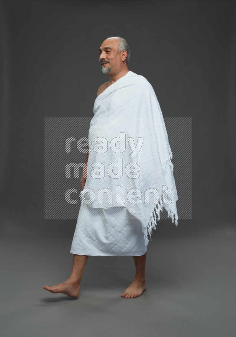 A man wearing Ehram Standing Interacting with the camera on gray background