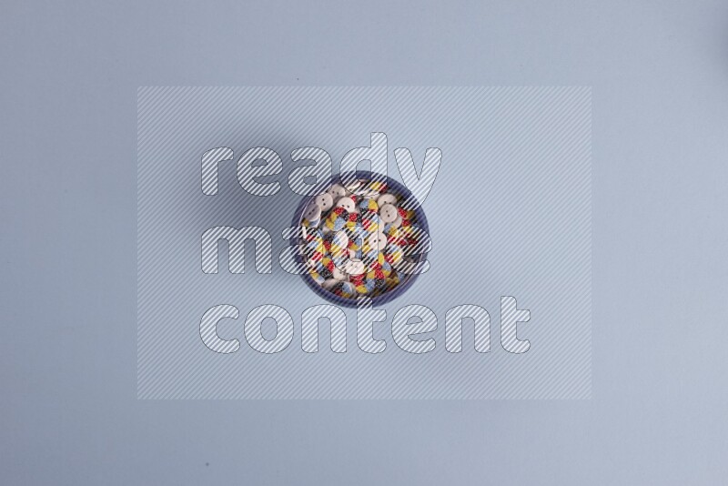 أوعية فخارية متعددة الألوان مليئة بالأزرار الملونة على خلفية زرقاء