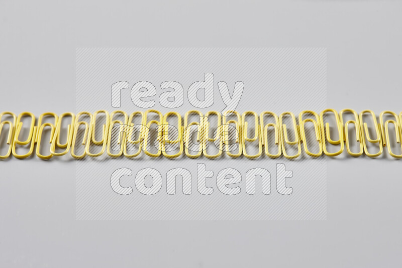 Yellow paper clips isolated on a grey background