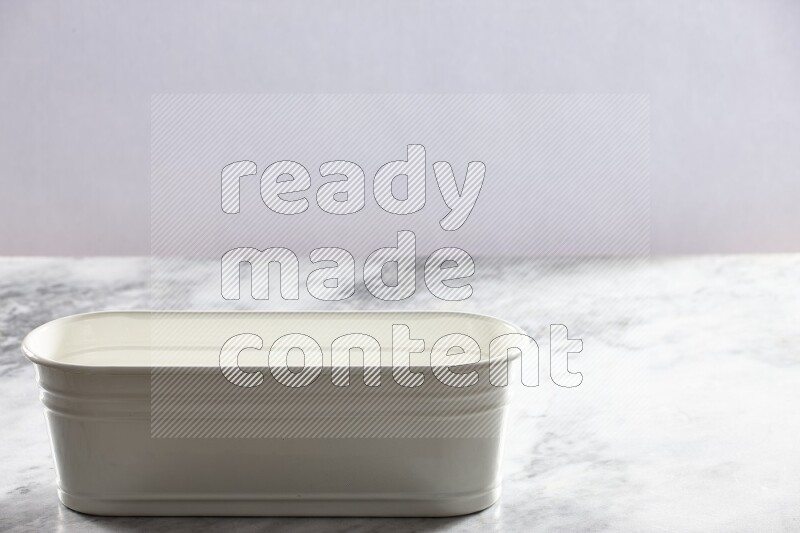 An empty white plant pot on grey marble background
