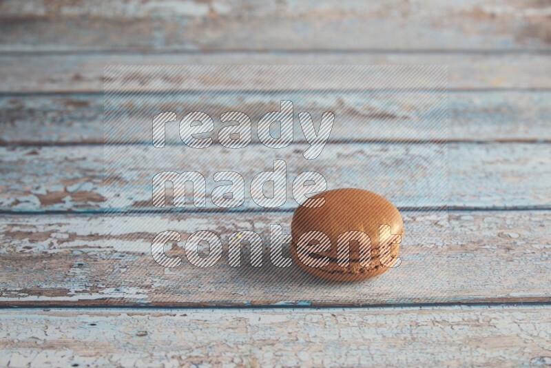 45º Shot of Brown Coffee macaron on light blue wooden background