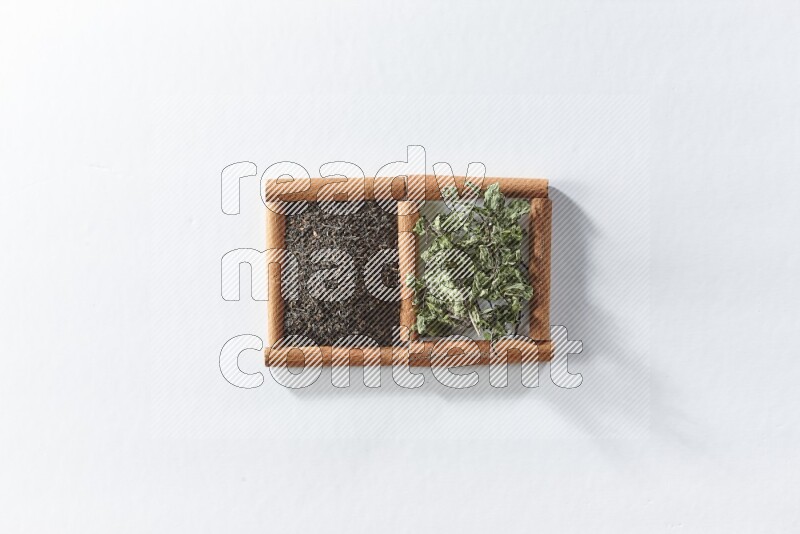 2 squares of cinnamon sticks full of black tea and dried mint leaves on white flooring