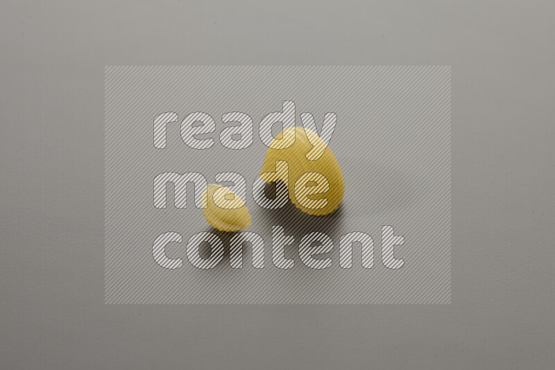 Shells pasta with other types of pasta on grey background