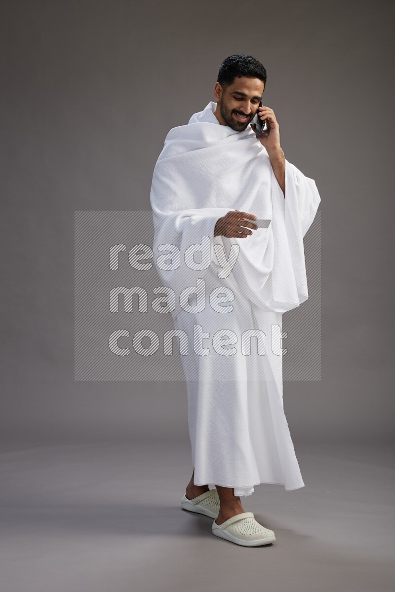 A man wearing Ehram Standing holding ATM card on gray background