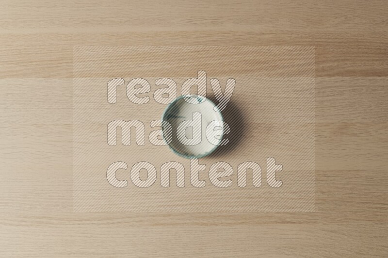 A multicolored pottery bowl on light wooden background
