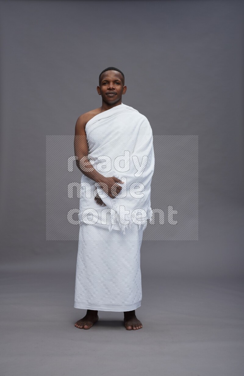 A man wearing Ehram Standing Interacting with the camera on gray background