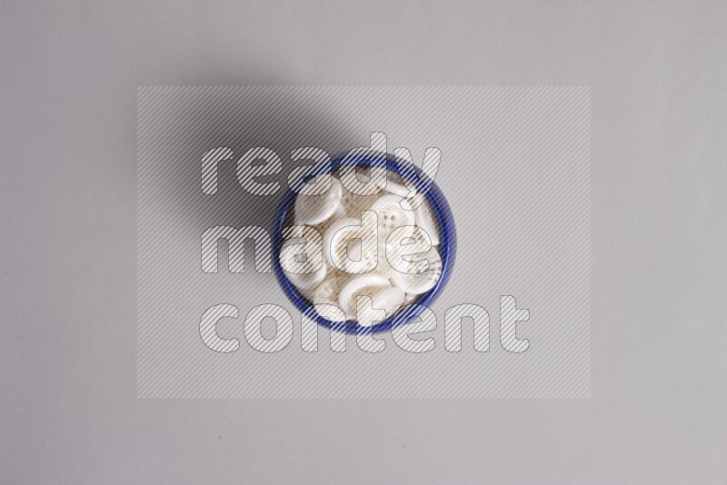 A multicolored pottery bowl full colored buttons on grey background