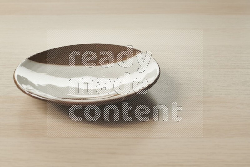 A multicolored pottery plate on light wooden background
