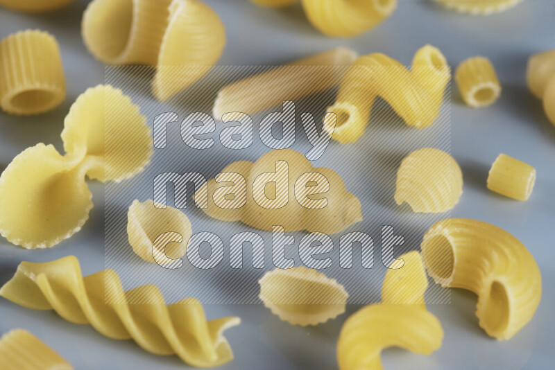 Different pasta types on light blue background