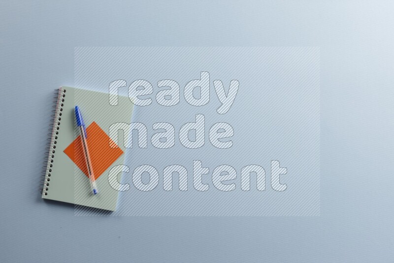 A blue notebook with different school supplies on blue background