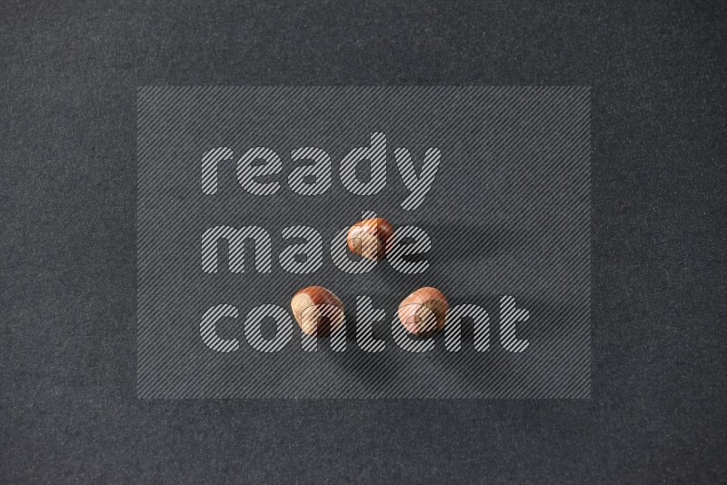 3 hazelnuts on a black background in different angles