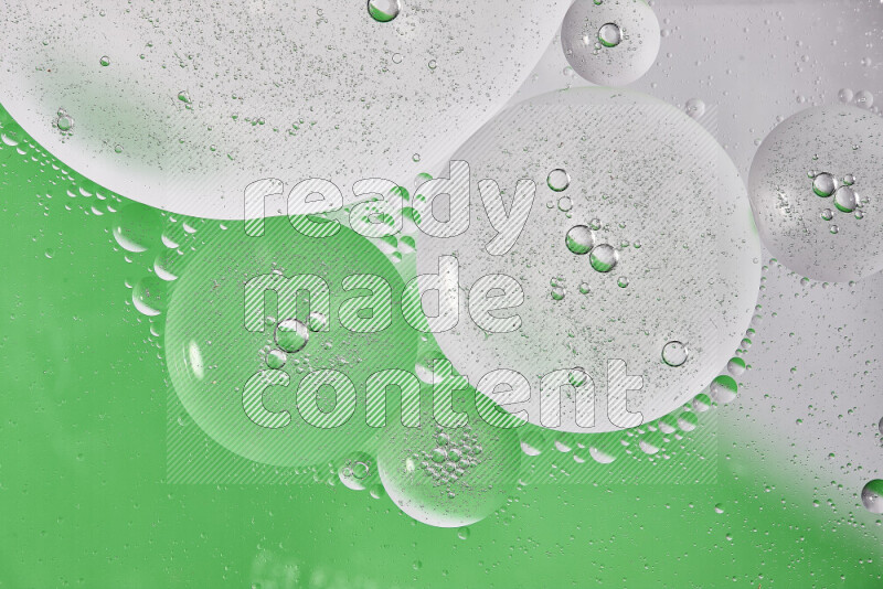 Close-ups of abstract oil bubbles on water surface in shades of white and green