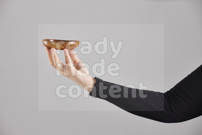 امرأة ترتدي عباءة سوداء تحمل أدوات خشبية مختلفة في أوضاع متعددة