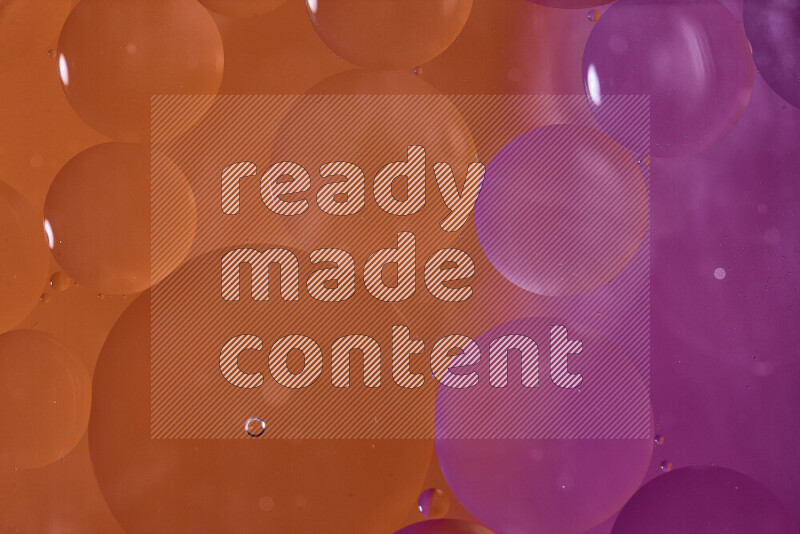 لقطات مقربة لفقاعات من الزيت على سطح الماء باللون البرتقالي والوردي