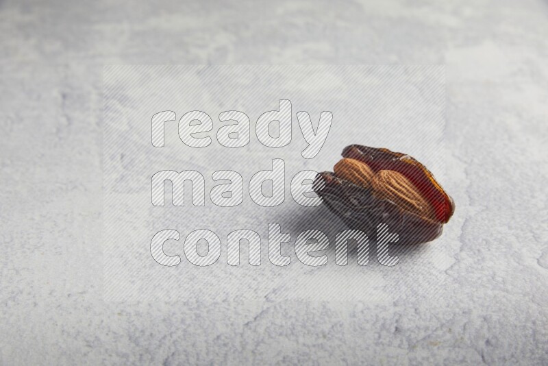almond stuffed madjoul date on a light grey background